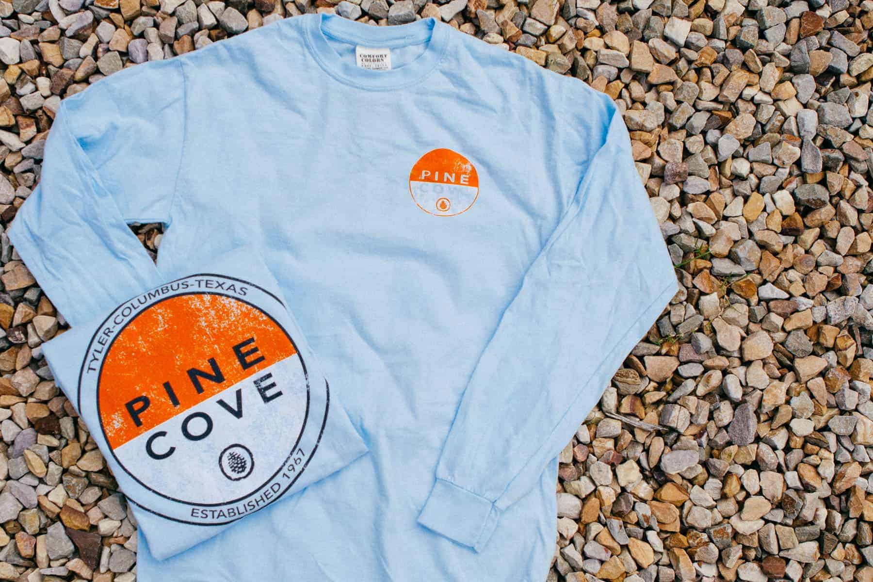 image of folded comfort colors shirt screen printed for Pine Cove on top of the long sleeve tee